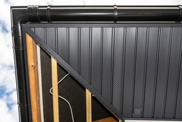 Scaffolding with three rows of wooden battens and a modern graphite soffit, visible H and J slats...