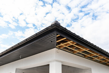 Scaffolding with three rows of wooden battens and a modern graphite soffit made in half, visible H...
