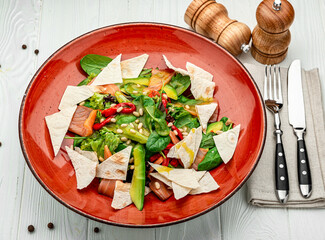 Salmon salad with spinach, vegetables and pine nuts.