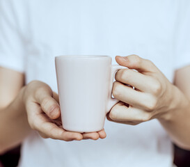 Person holding a cup of coffee.