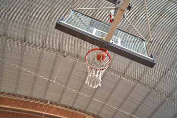 Close up of orange ball above the hoop net. Concept of success, scoring points and winning
