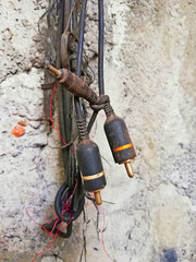 Old,rusty electronic cables,hanging on the wall