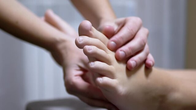 Masseur Hands Massage the Legs of a Child in a Massage Room. Pressing on acupuncture points feet with fingers, skin rubbing. Prevention of flat feet. Reflex, relaxing massage, treatment, help foots.