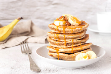 Wholegrain pancakes with banana and caramel sauce. Delicious breakfast.