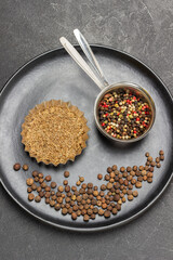 Allspice in metal bowl, fennel seeds in bowl and on black plate.