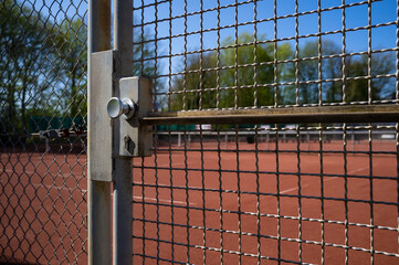 Entrance to the sports ground is fenced with a welded wire fence and a gate, on. Concept of a...