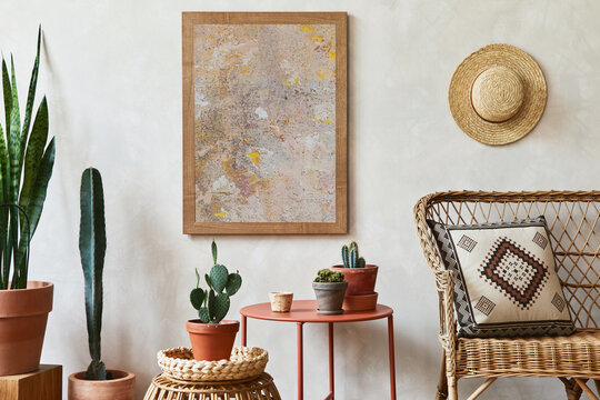 Creative composition of stylish living room interior with mock up poster frame, rattan armchair, coffee table, cacti and personal accessories. Plant love and nature concept. Template.