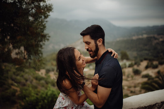 Loving couple embracing while standing against rural valley