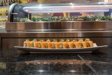 sushi with sauce on salmon roll served on a plate