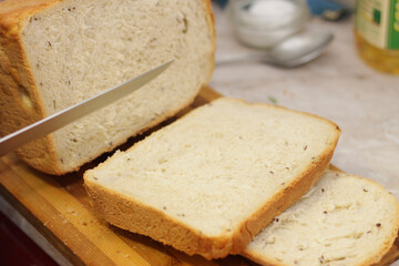 Woman cutting a bread on the wooden desk