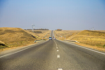 Road and moving cars at daytime and blue sky over