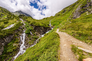 Fototapeta na wymiar Path leading towards Fran-Senn Hutte alongside a waterfall in austrian Stubai Alps.