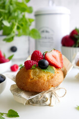 Muffin with fresh berries on the table with strawberries, blueberries, raspberries and mint close up