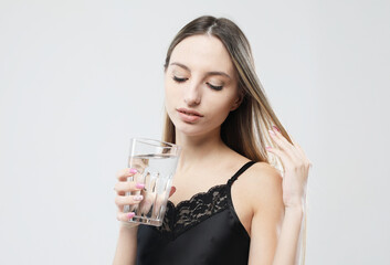 young woman wearing pajamas holding a glass of water