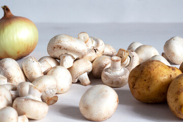 Ingredients for cooking. Champignon mushrooms, union and potatoes on a white background