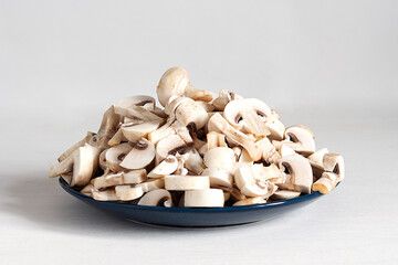 Sliced champignon mushrooms on a blue plate