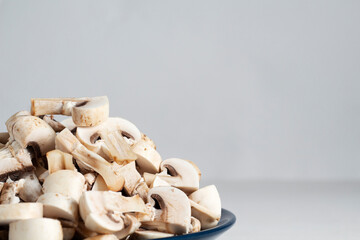 Sliced champignon mushrooms on a blue plate. copy space