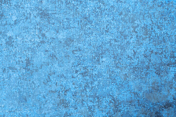 Textured blue background with protrusions and dents, a surface of lines and spots