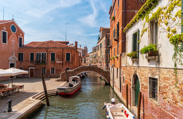 Venice, Italy. View of narrow canal with residential buildings of the Venetian district of Santa Croce in the summer morning. The inscriptionin italian: Ponte di Ruga Vecchia - Old fold Bridge.