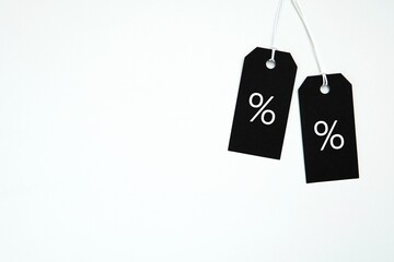 Black Friday sale concept, hanging two black price tags with percent sign, white background and space for text.