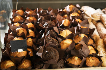 a lot of muffins or cupcakes on the shop window, homemade baking concept, sweets shop and honey cupcakes