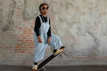 Little African kid boy with dreadlock hairstyle wear cool gold sunglasses, necklace chain, jeans...