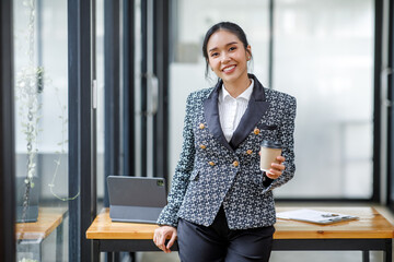 Charming Young Asian businesswoman standing in the office. Looking at camera.