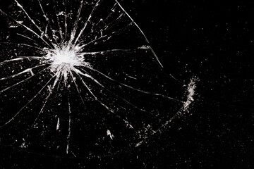 A ruined broken glass with compact shards around a hole in the upper right corner. Dark surface.
