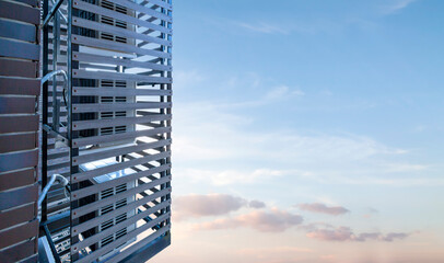 Air conditioner compressor unit HVAC on a roof of the building with blue sky and clouds in the...