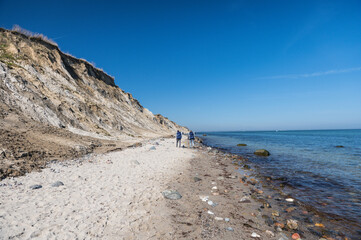 Beauty of big precipice at blu clear sea with stones beach