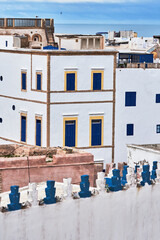 Detail of the medina of Essaouira, Morocco, with white buildings and blue windows, with the...