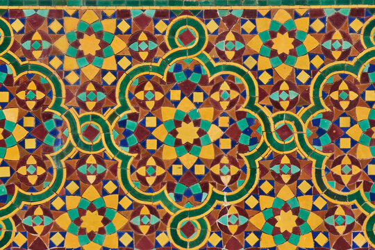 Detail of a moroccan painted multi-coloured traditional mosaic-tiled wall in blue, green, yellow, brown. Morocco
