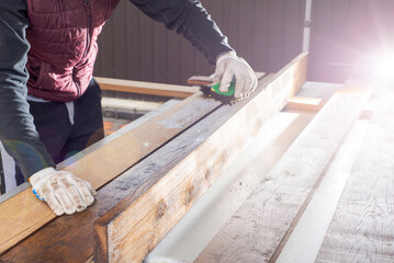 Brown color stain painting on wooden table or fence or wall, or flour, use for home decorated. House renovation. Half - painted surface. Hand holding brush. Background with copy space.