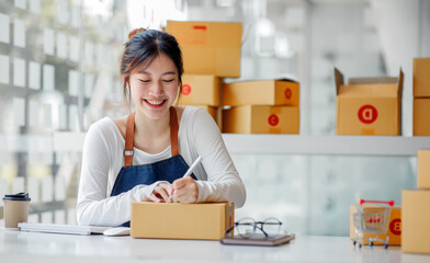 SME entrepreneur Small business entrepreneurs Online selling ideas,Happy Young Asian business owner work on computer and a boxs at home,delivery SME procurement package box deliver to customers,