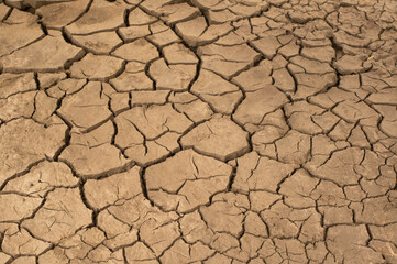 Dried cracked earthen soil, earth texture closeup