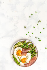 Grilled Toast witch Asparagus, Poached egg, bacon jamon, ham, prosciutto on white background. vertical image. top view. place for text