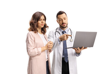 Doctor pointing at a laptop computer and standing with a young female patient
