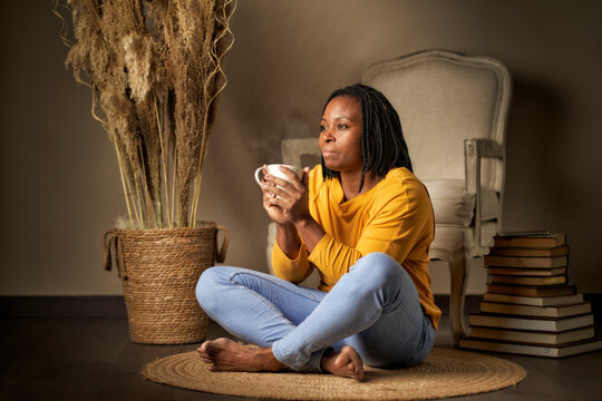 Portrait Of A Black Woman With Braided Hair Sitting Meditating On The Floor