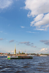 Fototapeta na wymiar view of the Neva River in St. Petersburg and tourist ships against the backdrop of the ancient Peter and Paul Fortress and the blue sky