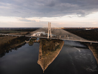 a large white suspension bridge over the river on which cars drive in Wroclaw, Poland, shot from a...