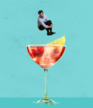 Contemporary art collage. Happy cheerful man jumping into refreshing tasty cocktail with fruity taste isolated over blue background