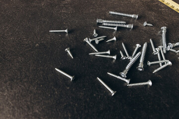 Roulette and screws on the table in the workshop. The hands of a wood master. Metal table legs. Desktop. Working process. Furniture creation.