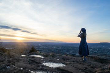 Woman standing on mountain with hands cupped to face