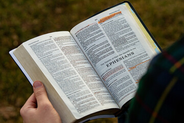 Closeup of open Bible in hands - Powered by Adobe