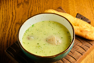 Peas soup in the yellow bowl on the wooden background.