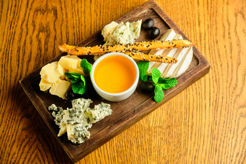 rye bruschetta with honey pumpkin and goat cheese on a dark wood background. tinting. selective focus on mint on the front bruschetta