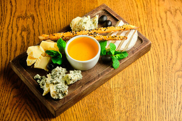 rye bruschetta with honey pumpkin and goat cheese on a dark wood background. tinting. selective focus on mint on the front bruschetta