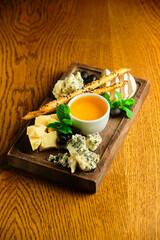 rye bruschetta with honey pumpkin and goat cheese on a dark wood background. tinting. selective focus on mint on the front bruschetta