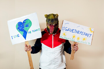 Man with a lizard head in studio WITH cardboard sign that says #SAVETHEPLANET and I LOVE THE PLANET