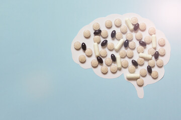 Illustration with paper brain cutout and medical vitamin pills